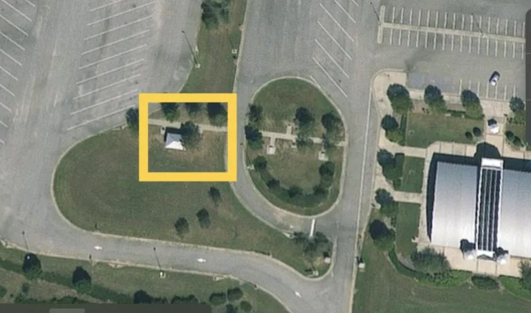 Aerial view of a parking lot and adjacent structures, possibly related to an event area.